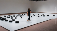 Instalación Murmuring Minds de DRIFT con bloques autónomos interactuando con una persona en LUMA Arles.