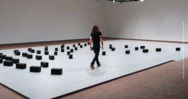 Instalación Murmuring Minds de DRIFT con bloques autónomos interactuando con una persona en LUMA Arles.